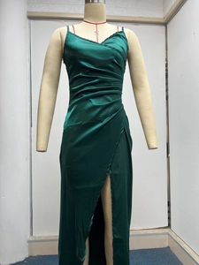 Detail view of dark green satin dress featuring ruched bodice and high side slit