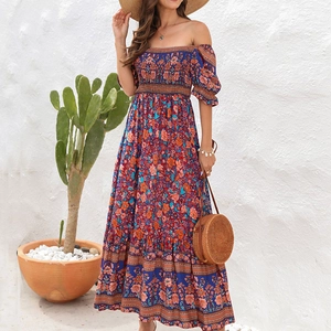Detail of bohemian floral off-shoulder maxi dress with tiered skirt and puff sleeves