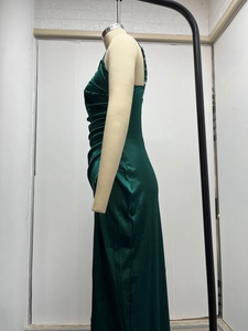 Detail of ruched side seam on dark green satin dress with elegant silky sheen texture