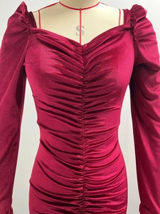 Detail of burgundy velvet dress featuring a sweetheart neckline and ruched texture