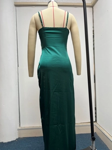 Detail view of the emerald green satin dress back showing a sleek invisible zipper closure