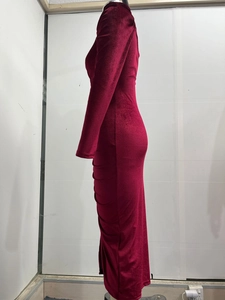 Detail view of burgundy velvet dress featuring elegant ruching and a side slit