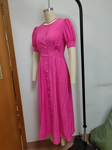Macro detail of the round neckline and single-breasted white buttons on pink dress