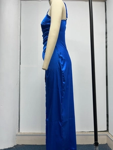 Detail of royal blue satin maxi dress showing side slit and elegant ruching texture