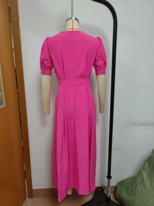 Detail of rose red dress back view with puff sleeves and waist pleats on mannequin