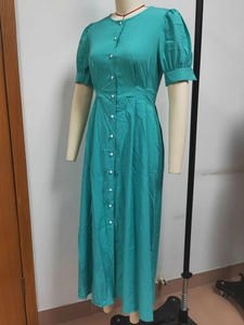 Detail view of teal button-down midi dress showing short puff sleeves and woven fabric texture