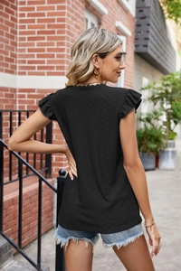 Détail du dos d'un haut noir pour femme avec broderie ajourée et manches à volants