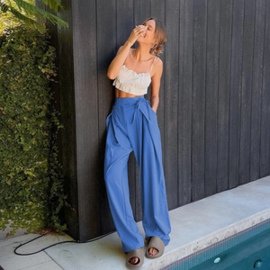 Detail of high-waist royal blue wide-leg trousers with drawstring waist and fluid drape