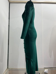 Detail of ruched side seams on dark green velvet long sleeve dress with high slit