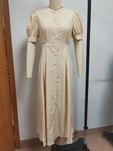 Detail view of cream short puff sleeve midi dress with single-breasted white button closure