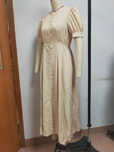 Detail view of beige puff sleeves and single-breasted button placket on a midi dress