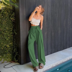 Close-up of high-waisted dark green wide leg trousers with premium draped fabric effect