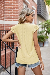 Détail du tissu en dentelle anglaise jaune clair avec manches à volants et texture ajourée
