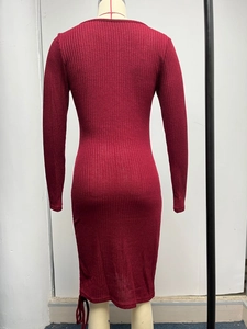 Macro shot of red ribbed knit dress featuring a side drawstring and ruched hem details