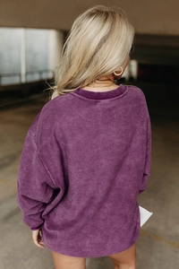 Détail du sweat-shirt violet oversize montrant la texture côtelée à l'arrière