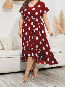 Dettaglio di un abito rosso a pois taglie forti con scollo a V e bordo a balze