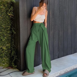 Detail view of high waisted dark green wide leg trousers with matching waist tie
