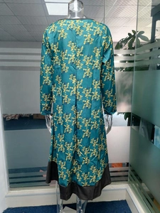 Vue détaillée du dos d'une robe vintage à fleurs avec tissu vert et bordure noire