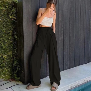 Detail of high waisted black wide leg trousers featuring a premium draped casual fit