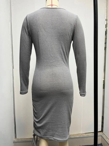 Detail view of grey ribbed knit dress featuring side drawstring ruching and fabric texture