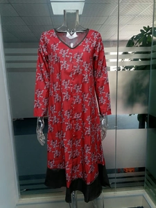 Détail de la robe rouge à col en V avec imprimé floral et bordure noire en bas