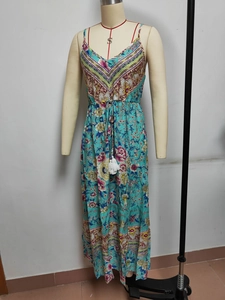 Detail of bohemian floral maxi dress featuring a drawstring waist and tassel accents