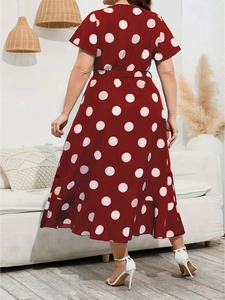 Dettaglio dell'abito lungo rosso a pois con vita elastica, cintura e bordo a balze