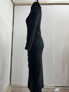 Detailed side view of black velvet ruched long sleeve dress with slit elegant texture