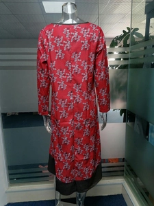Détail du dos d'une robe rouge à fleurs avec bordures noires et manches trois-quarts