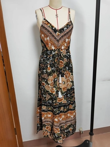 Detail of bohemian floral maxi dress featuring white waist tassels and V-neckline style