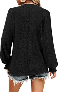 Detail of black V-neck lace top featuring eyelet embroidery and ruffled sleeves