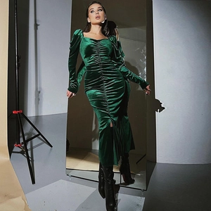 Detail of emerald green velvet dress showing ruched neckline and slim fit design