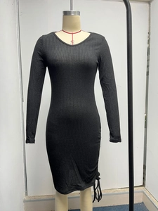 Close-up of black ribbed knit fabric with side drawstring ruched detail on a slim dress