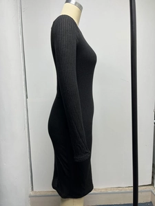 Close-up of the vertical ribbed knit fabric and ruched side detail on this black slim dress