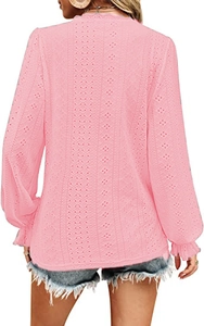 Detail of pink lace top featuring hollow-out floral texture and ruffled sleeve cuffs