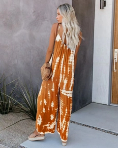 Detail view of mustard yellow tie-dye jumpsuit with thin straps and backless design