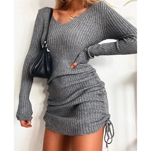 Detail view of the ribbed knit texture and adjustable drawstring hem on this grey V-neck dress