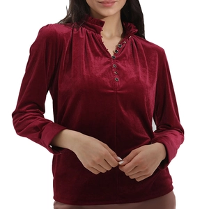Détail de chemise en velours bordeaux avec col à volants et texture boutonnée élégante