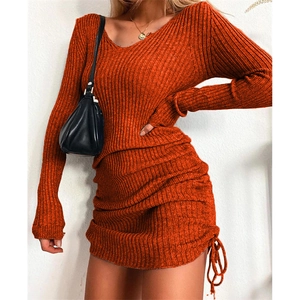 Close-up of orange ribbed knit dress featuring side drawstring and pleated texture detail
