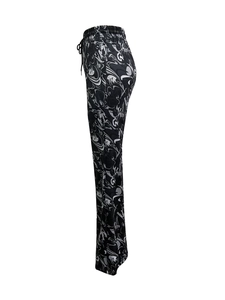 Détail du pantalon évasé à motif marbré avec taille haute et cordon de serrage