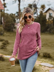 Detail showing pink ribbed knit fabric texture of a long sleeve crewneck top