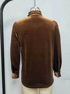 Détail du dos d'un chemisier en velours marron avec col volanté et manches bouffantes