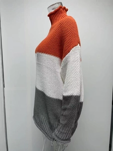 Detail eines Blockfarben-Strickpullovers mit Rollkragen und dekorativem Rüschensaum