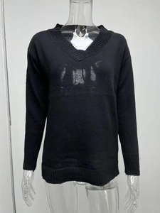 Detail of ribbed V-neckline and sleeve cuffs on a classic black long sleeve sweater