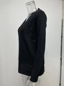 Detail view of the ribbed cuffs and hem on a black V-neck long sleeve knit sweater