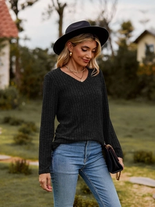 Detalle de blusa gris oscuro de manga larga con cuello en V y tejido de punto acanalado