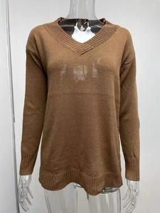 Close-up of V-neckline and ribbed knit texture on the brown long sleeve sweater
