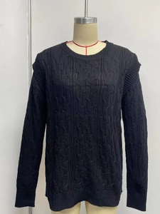 Detailed close-up of thick black cable knit pattern on loose long sleeve sweater