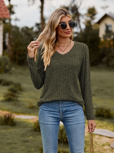 Detalle de blusa de punto acanalado verde oscuro con cuello en V y manga larga casual