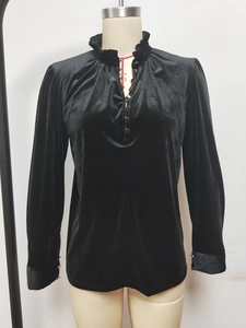 Détail du col à volants et de la patte de boutonnage sur ce haut en velours noir à manches